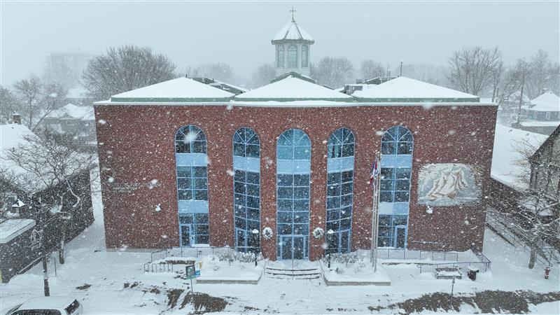 A phot of a square brick building covered in snow